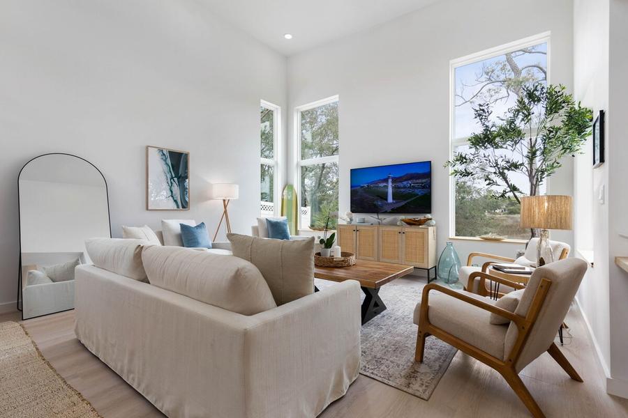 Bright living room with tall windows, a linen sofa and coastal decor