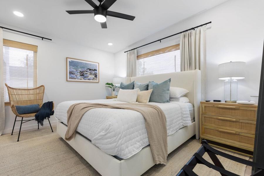 Bedroom 1 with a king bed, rattan dresser and ceiling fan
