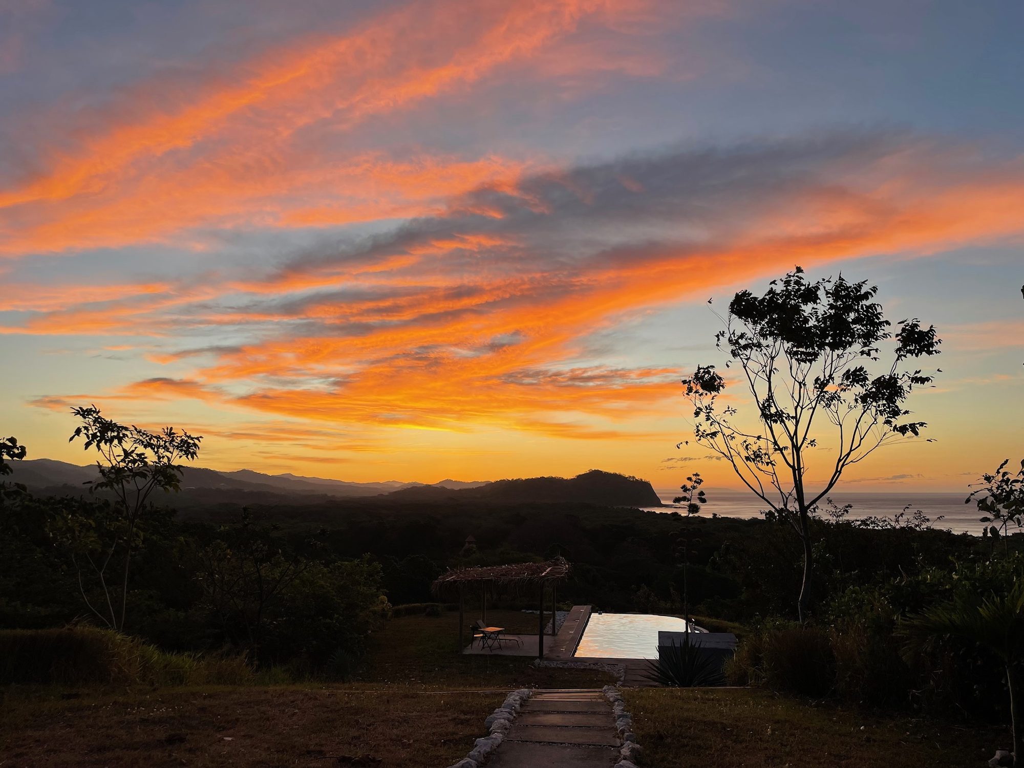Orange and pink sunset over the hills and the ocean